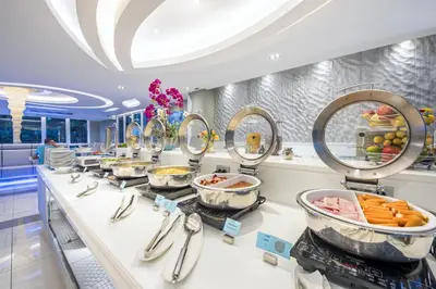 a buffet line in a restaurant with many dishes at Le Tada Residence in Bangkok