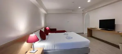 a hotel room with a bed and a flat screen tv at Le Tada Residence in Bangkok
