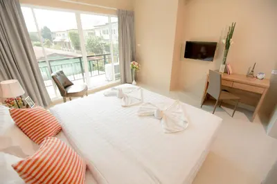 a bedroom with a large white bed and a desk at The Bedroom Ladprao 101 Bangkok - SHA in Bangkok