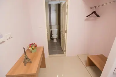 a bathroom with a toilet and a wooden table at The Bedroom Ladprao 101 Bangkok - SHA in Bangkok