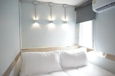 a bedroom with a bed with lights above it at KENCOZY accommodation in Bangkok