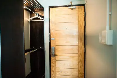 a wooden door in a room with a closet at KENCOZY accommodation in Bangkok