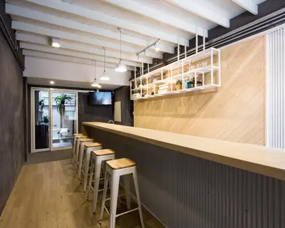 a row of stools in a restaurant with a bar at On the Bed Hostel in Bangkok