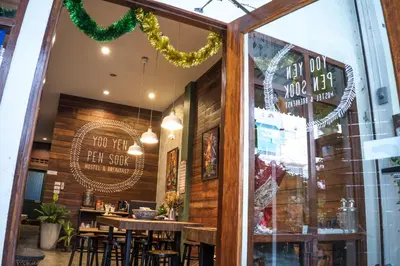 a restaurant with a table and chairs in the window at Yoo Yen Pen Sook in Bangkok