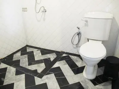 a bathroom with a toilet and a black and white floor at J No.14 in Bangkok