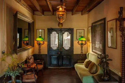 a living room with a couch and a door at Metropole, Bangkok, a Tribute Portfolio Hotel by Marriott in Bangkok