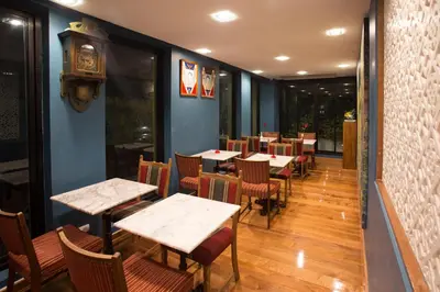 a restaurant with tables and chairs and a clock on the wall at Nine Design Place in Bangkok