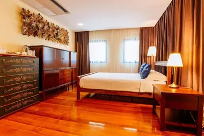 a bedroom with a bed and a dresser and a desk at Nine Design Place in Bangkok