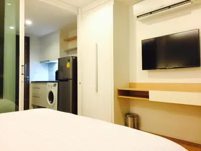 a room with a bed and a tv on a wall at Luxury Suite @ BTS Nana in Bangkok