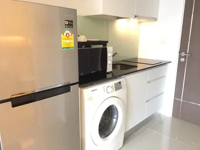 a kitchen with a washing machine and a microwave at Luxury Suite @ BTS Nana in Bangkok