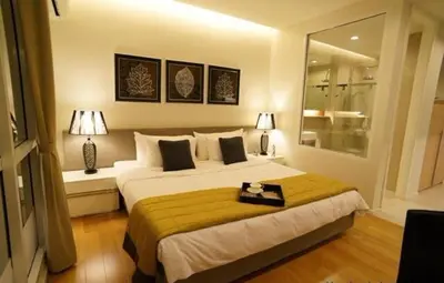 a bedroom with a large bed and two lamps at Luxury Suite @ BTS Nana in Bangkok