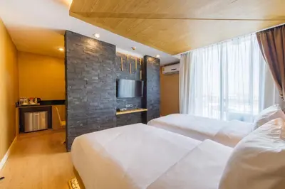 a hotel room with two beds and a tv at Zenniq in Bangkok