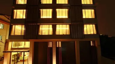 a tall building with lit windows at night at Collection O The Bangkok Cha Cha Suite in Bangkok