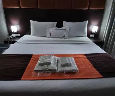 a bed with two bags on top of it at Collection O The Bangkok Cha Cha Suite in Bangkok