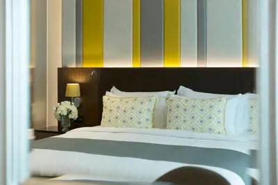 a bedroom with a large bed with colorful stripes at Lancaster Bangkok in Bangkok