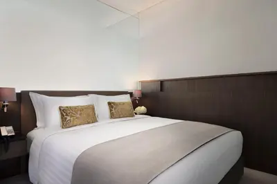 a bedroom with a large white bed with two pillows at Lancaster Bangkok in Bangkok