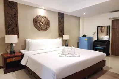 a hotel room with a large bed with towels on it at Kim Hotel At Bangplong in Bangkok