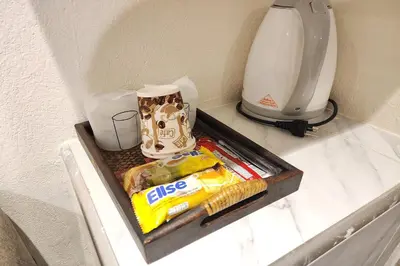 a shelf with snacks and a coffee maker on it at Kim Hotel At Bangplong in Bangkok