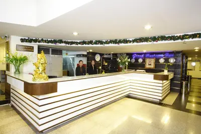 a bar in a hotel with people behind the counter at Grand Business Inn in Bangkok