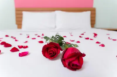 a group of red roses on a bed with hearts at The Garden Place Bangkok in Nonthaburi