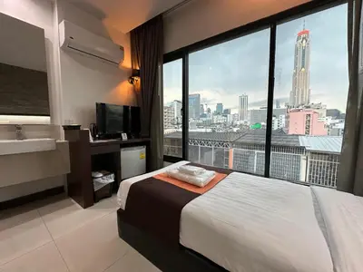 a hotel room with a bed and a large window at Collection O The Bangkok Airport Link Suite in Bangkok
