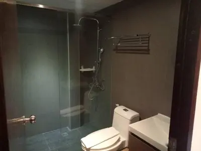 a bathroom with a toilet and a glass shower at Collection O The Bangkok Airport Link Suite in Bangkok