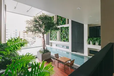 a pool in the middle of a building with plants at Mii Hotel Srinakarin in Bangna