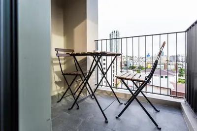 a table and two chairs on a balcony at Mii Hotel Srinakarin in Bangna