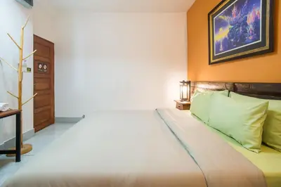 a bedroom with a bed and a picture on the wall at Banthat Thong Hostel in Bangkok
