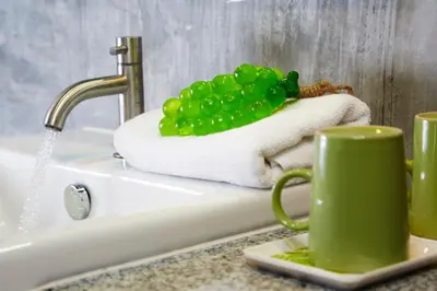 a green coffee mug sitting on a counter next to a sink at Uncle Loy's Boutique House in Bangkok