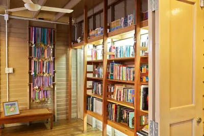 a library with wooden shelves filled with books at Uncle Loy's Boutique House in Bangkok