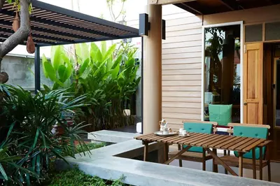 a patio with a wooden table and chairs on a house at Uncle Loy's Boutique House in Bangkok