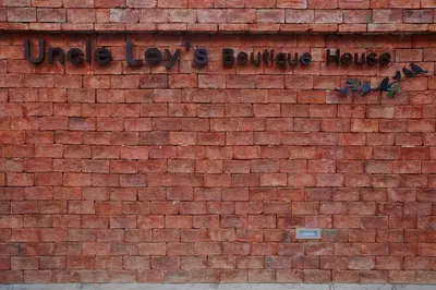a brick wall with the words uo dogs and bounce house on it at Uncle Loy's Boutique House in Bangkok