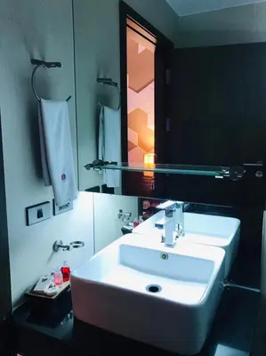 a bathroom with a white sink and a mirror at Paradiso Boutique Suites in Bangkok
