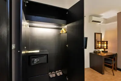 a bathroom with black walls and a table and a mirror at Royal View Resort - Rang Nam in Bangkok