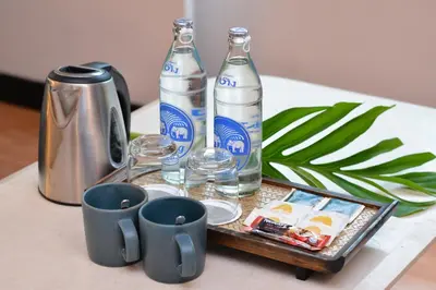 a tray with two bottles and two cups on a table at Royal View Resort - Rang Nam in Bangkok