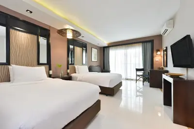 a hotel room with two beds and a flat screen tv at Royal View Resort - Rang Nam in Bangkok