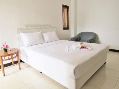 a bedroom with a large white bed with a chair at JL Bangkok Hotel in Bangkok