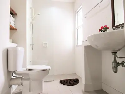 a white bathroom with a toilet and a sink at JL Bangkok Hotel in Bangkok