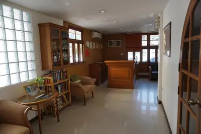 a hallway with a living room with chairs and a table at JL Bangkok Hotel in Bangkok