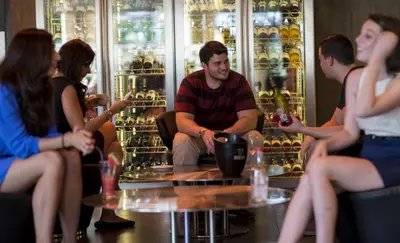 a group of people sitting around a table with wine bottles at Sukhumvit Suites Hotel in Bangkok