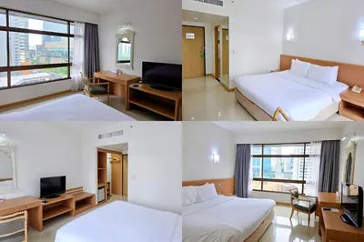 a hotel room with two beds and a television at Pinnacle Lumpini Park Hotel in Bangkok
