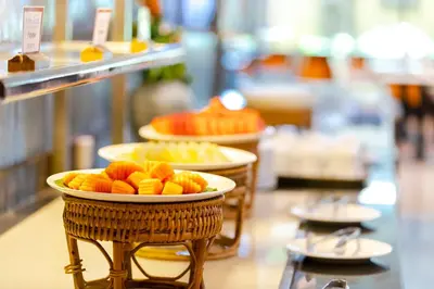 a buffet with two plates of fruit on display at Pinnacle Lumpini Park Hotel in Bangkok