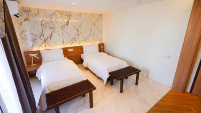 a room with two beds and a table and benches at Pinnacle Dream in Bangkok