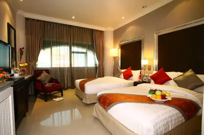 a hotel room with two beds with a bowl of fruit at Hope Land Hotel 46/1 in Bangkok