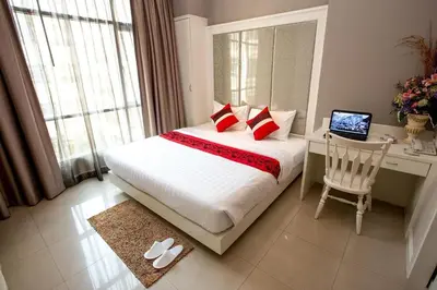 a bedroom with a bed and a desk with a laptop at Hope Land Hotel 46/1 in Bangkok