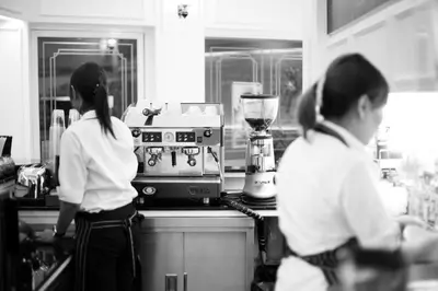 two women standing in a kitchen with a blender at Khaosan Palace Hotel in Bangkok