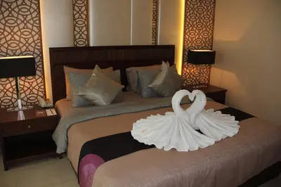 a bedroom with a bed with two swans on it at De Arni Bangkok - SHA Extra Plus in Bangkok