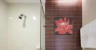 a bathroom with a shower with a painting of a flower at Grand Richmond Stylish Convention Hotel in Nonthaburi