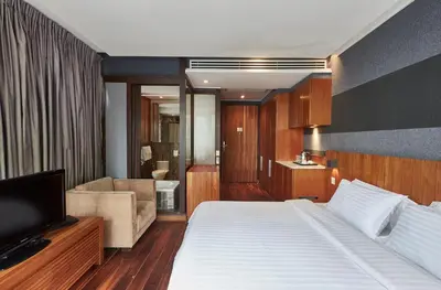 a hotel room with a bed and a living room at LUXX Langsuan Hotel - SHA Plus in Bangkok